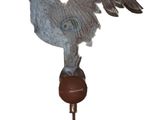 a statue of a bird that is on top of a wooden stand