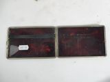 two empty wallets sitting on a white table