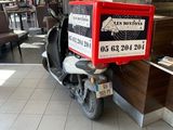 a scooter with a box on the back of it in a restaurant