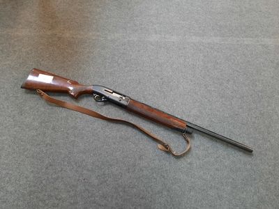 an old rifle with a wooden handle and a leather strap