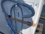 a white washer sitting on a pallet with a hose attached to it