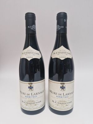 deux bouteilles de vin rouge posées l'une à côté de l'autre sur une surface blanche