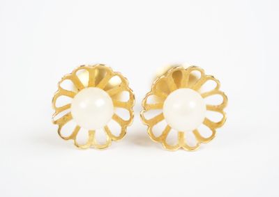 a pair of gold and white flower earrings on a white background
