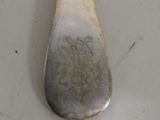 a silver spoon with a picture on it sitting on a table