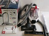a vacuum that is sitting on a table next to a box of vacuum cleaners