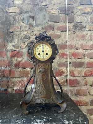 une horloge posée sur une table devant un mur de briques