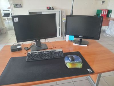 a computer desk with two monitors and a mouse