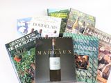 beaucoup de livres et une bouteille de vin sur la table