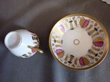 a cup and saucer sitting on a table next to a plate
