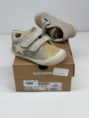 une boîte sur laquelle est posée une paire de chaussures de bébé