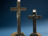 pair of wooden crosses with a plaque on each of them on a blue surface