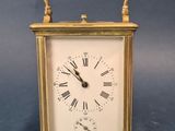 a small gold clock with roman numerals on it