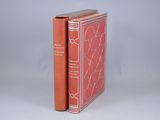 two red books sitting on top of each other on a white surface