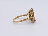 a close up of a gold ring with pink stones on a white surface