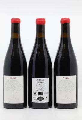 trois bouteilles de vin rouge posées l'une à côté de l'autre sur une surface blanche