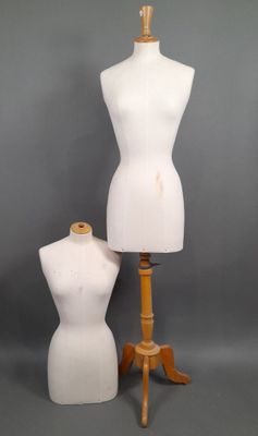 two white mannequins on a wooden tripod stand against a gray background