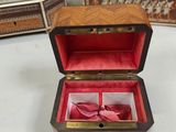 a small wooden box with a pair of red shoes in it