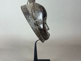 a bronze sculpture of a woman ' s head on a black stand