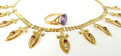 un gros plan d'un collier et d'une bague posés sur une surface blanche