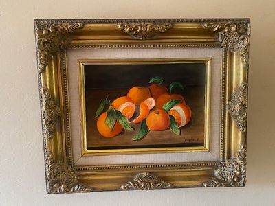 une photo d'un tableau représentant des oranges, dans un cadre doré