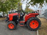 a red tractor that is parked in the parking lot