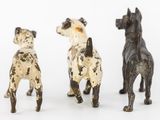 three small figurines of dogs standing next to each other