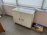a white cabinet in the corner of a room next to a window