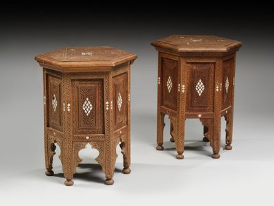 a pair of small wooden tables with carvings on them