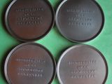 four metal tins with words on them sitting on a green surface