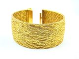 gros plan d'un bracelet en or sur fond blanc