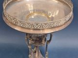 an antique silver plate on a stand on a blue background