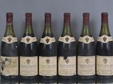 six bouteilles de vin sont alignées sur une table