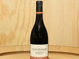 une bouteille de vin posée sur un tonneau