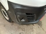the front bumper of a white van with a black grille
