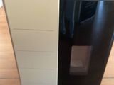une photo d'un réfrigérateur en noir et blanc posé sur un parquet