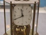 une horloge en or posée sur une vitrine