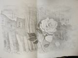a drawing of a rose in a book on a table