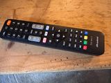 a remote control that is sitting on a wooden table