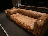un canapé en cuir marron exposé dans une pièce