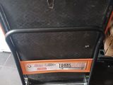 an orange and black suitcase sitting on top of a black table