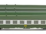 a green and white train on the tracks with a red and white car