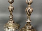 pair of antique brass candlesticks on a grey background
