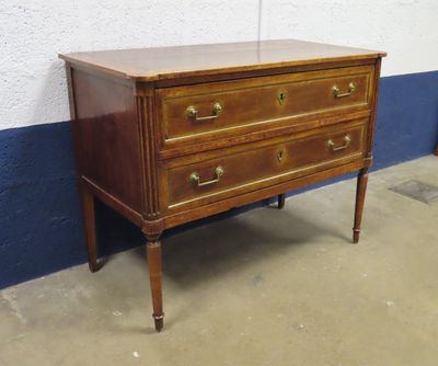une commode ancienne dans une pièce aux murs bleus et blancs