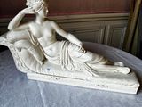 a statue of a woman sitting on a couch