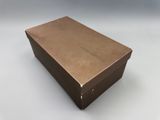 an open box with a brown lid sitting on a white surface