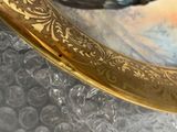 a close up of a gold plate with a bird on it