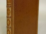 a brown leather book with gold trimming and gold trimming