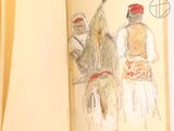 two people that are drawing in a book