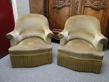 une paire de fauteuils rembourrés beiges placés devant un meuble en bois