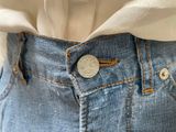 a close up of a person ' s jeans with a coin in the back pocket